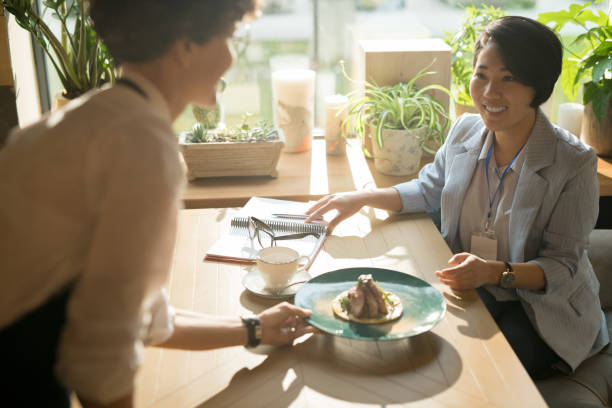 istock Waitress bringing order to Asian business lady 1077743176
