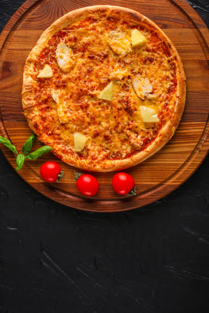 istock pizza, pineapple, chicken, tomato sauce, cheese, basil (pizza ingredients). Hawaiian pizza. Top view. copy space 1077743472