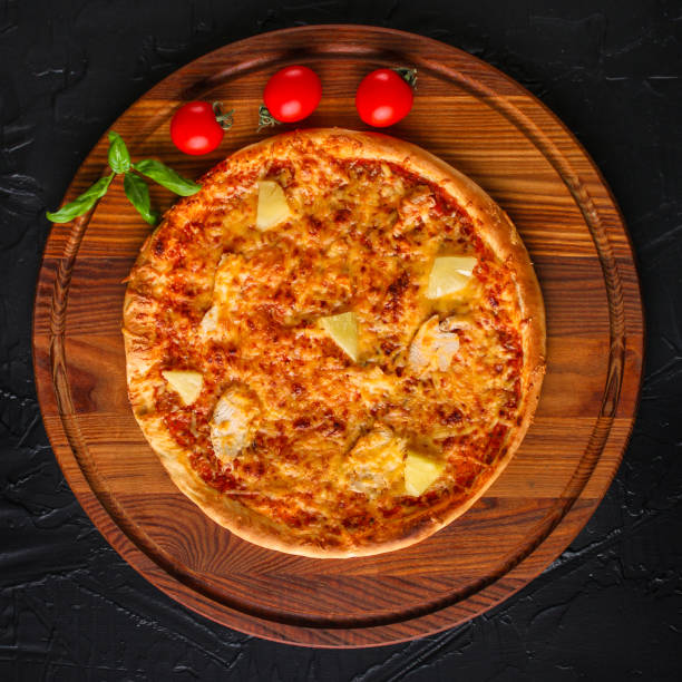 istock pizza, pineapple, chicken, tomato sauce, cheese, basil (pizza ingredients). Hawaiian pizza. Top view. copy space 1077743482