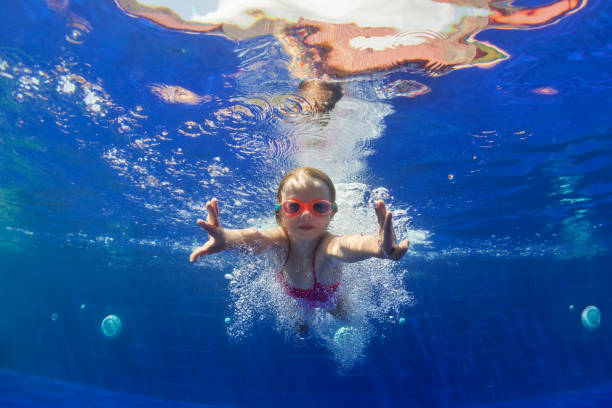 забавный ребенок в очках ныряет в бассейн - swimming child swimming pool indoors стоковые фото и изображения