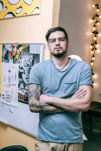 istock Muscled good-looking man crossing his hands covered in tattoos 1077744098