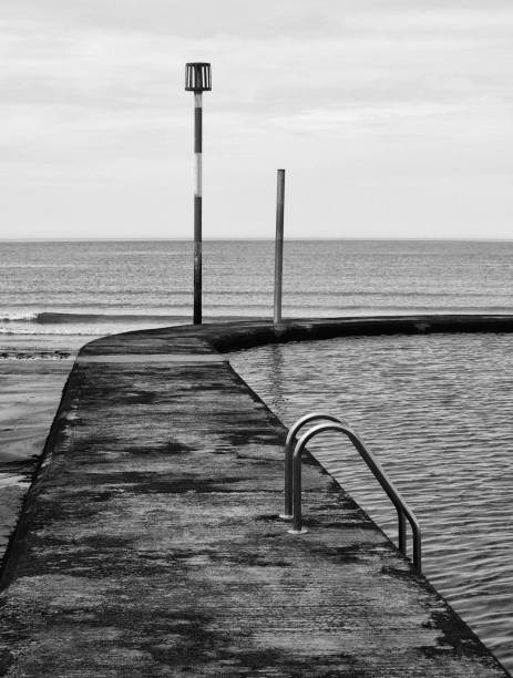 immagine monocromatica di un vecchio lido di cemento o piscina di acqua di mare nel margate kent - sea defence concrete foto e immagini stock