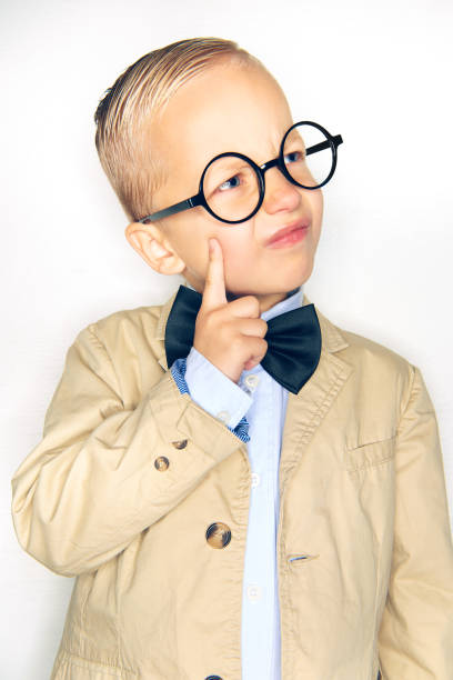 istock Little boy wearing a bowtie and glasses deep in thought 1077744290