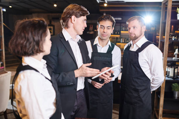 istock Confident restaurant manager discussing seating chart with waite 1077746442
