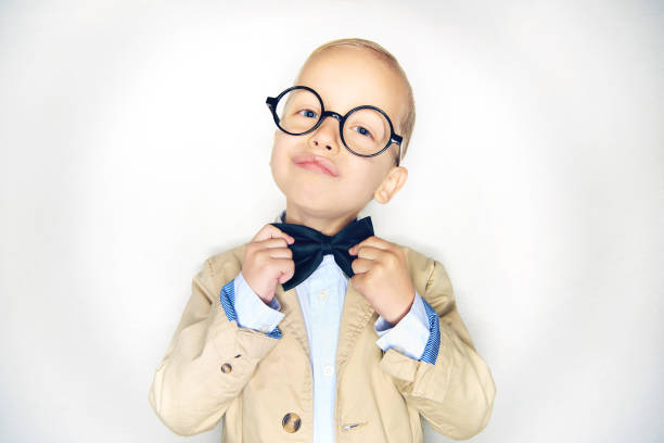 istock Smiling little boy wearing glasses adjusting his bowtie 1077746732