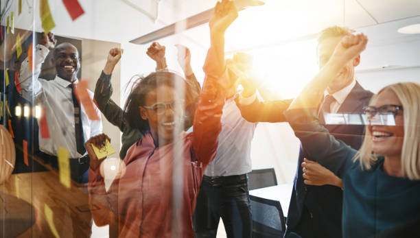 istock Ecstatic businesspeople cheering togegther after an office brainstorming session 1077754352