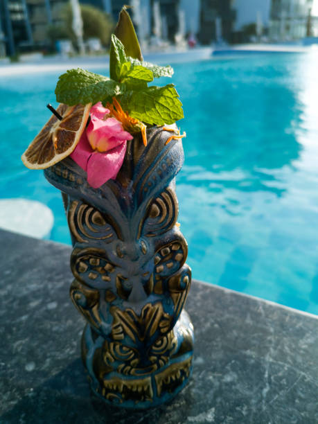 Tiki cocktail in blue mug next to a swimming pool Tiki cocktails are characterized for being fun, colorful, fruity and served in their own specialized vessels known as tiki mugs, that lovers of Hawaiian and Polynesian cultures collect.
Cocktails have become popular again thanks to the improved craftsmanship of the last 10 years that have followed the excitement and cosmopolitan life of the late 1990's and early 2000's when celebration and nights out were popular. Nowadays it is possible to enjoy classic cocktails as well as signatures at each bar and restaurant no matter if it is in a city or next to the beach. mai tai hawaii stock pictures, royalty-free photos & images