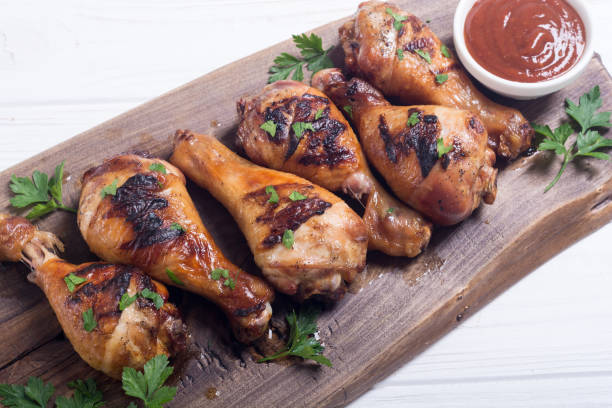 istock Grilled chicken legs with tomato sauce BBQ food background 1077754664