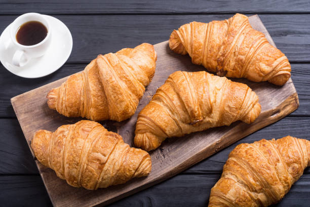 istock Croissants on wooden background 1077754678