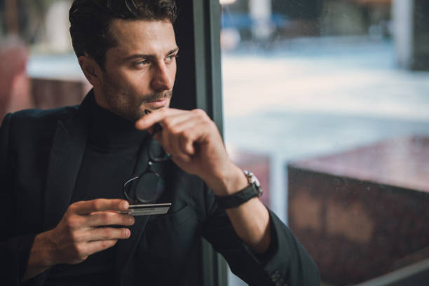 istock Handsome man holding his credit card 1077754964