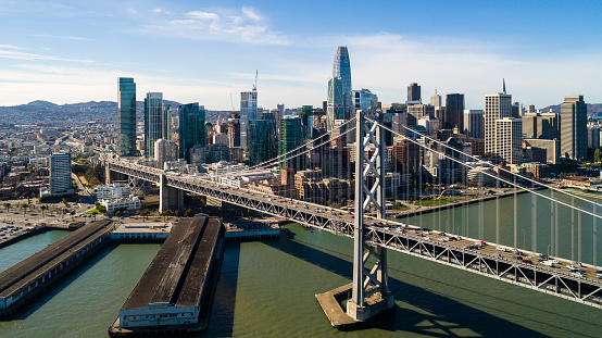 The aerial drone scenic panoramic view of San Francisco Downtown over the Oakland Bay Bridge with the car traffic. Northern California, USA.
