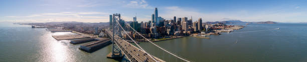 The aerial view of San Francisco Downtown over the Oakland Bay Bridge The aerial drone scenic panoramic view of San Francisco Downtown over the Oakland Bay Bridge with the car traffic. Northern California, USA. san francisco bay stock pictures, royalty-free photos & images
