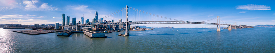 The aerial drone scenic view of San Francisco, California. The extra-wide stitched panorama of the Oakland Bay Bridge over the San Francisco Bay, between Downtown and Treasure Island. Northern California, USA
