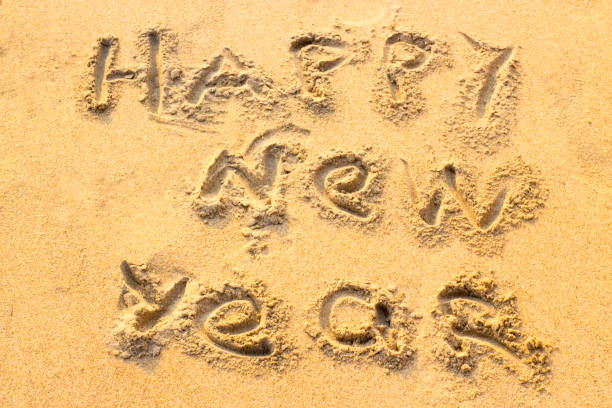 istock Handwriting Happy New Year on the sand. 1077765648