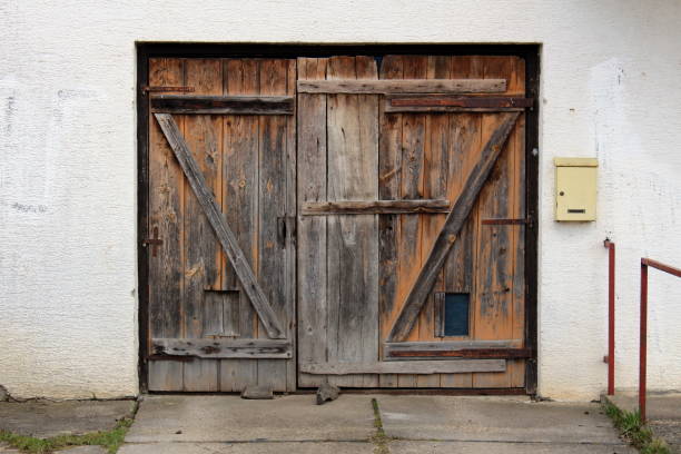 istock Old dilapidated wooden garage doors with mailbox mounted on right side wall 1077772072