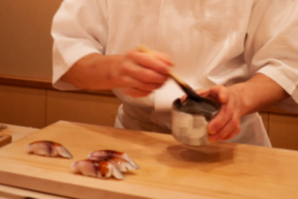 istock Blurred. Motion. Professional sushi chef carefully add final touch with confident and dedication to his perfect sushi. 1077786502