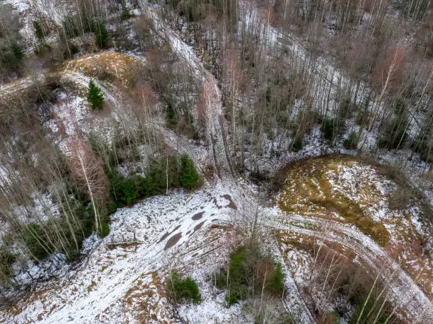 Aerial view of a forestroad in winterland, autumn - winter forest from the sky,