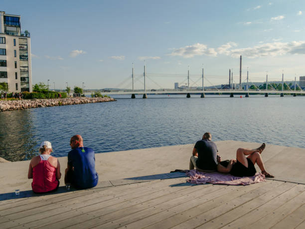Summer Evening in Sweden City: Two couples relaxing on the deck at the lake. Munksjon Lake Shore in the historical province Småland, Sweden. Munksjon Lake Shore in the historical province Småland, Sweden. - July 06, 2018. jonkoping stock pictures, royalty-free photos & images