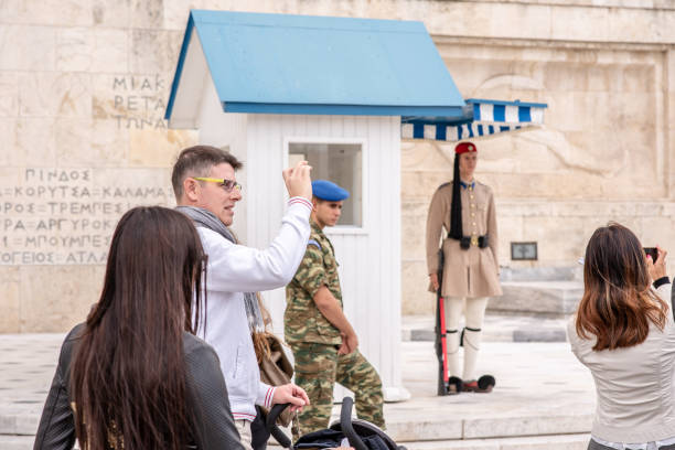 man taking a photo at the parliament building in athens, greece - tourist photographing armed forces military imagens e fotografias de stock