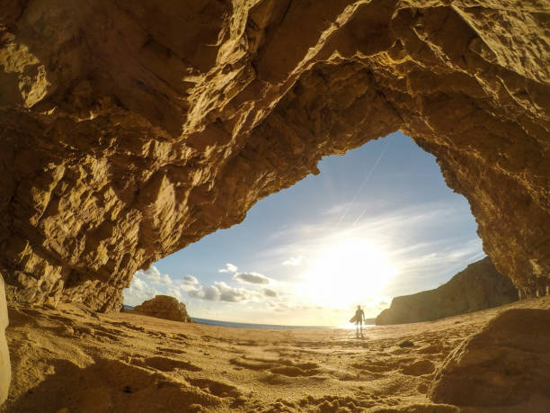 istock Surfer walking away into the sun 1077797534