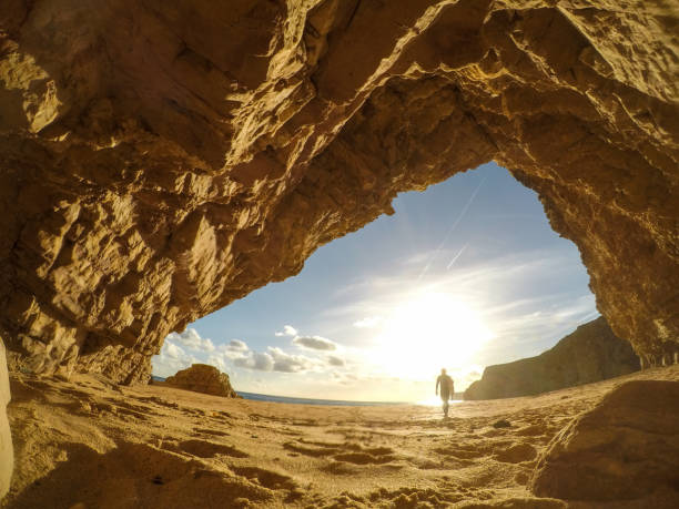 istock Surfer walking away into the sun 1077797824