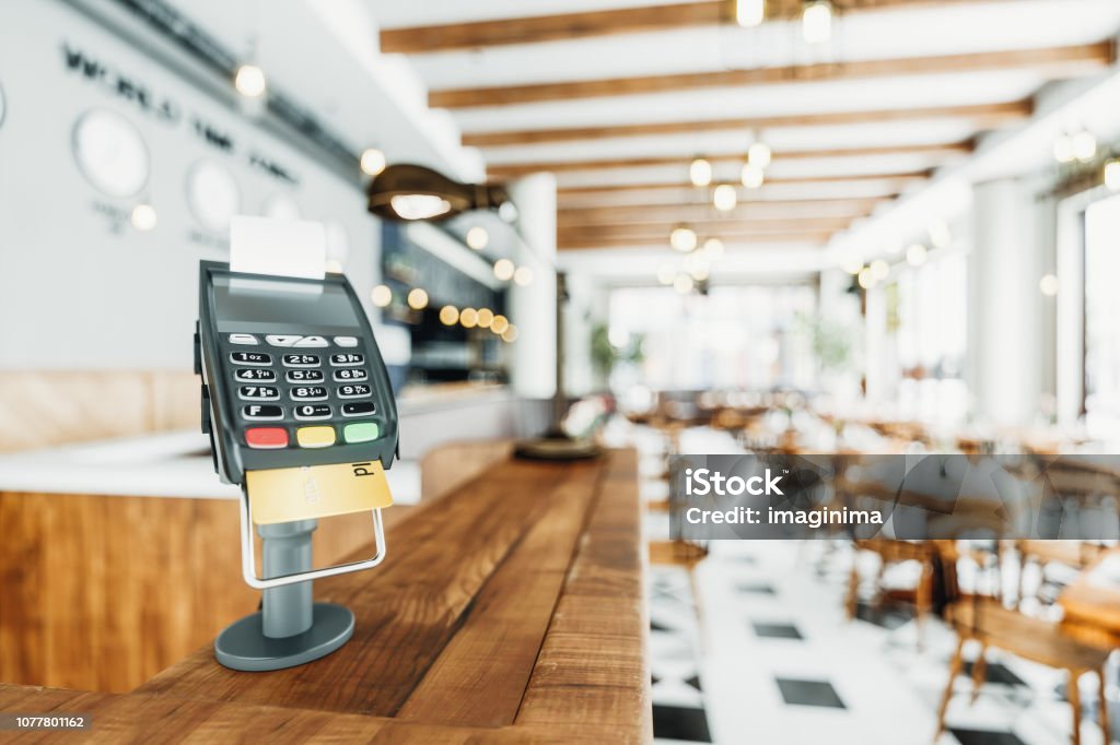 Counter-top Payment Terminal In A Restaurant Close-up shot of a counter-top payment terminal in an empty restaurant. Cash Register Stock Photo