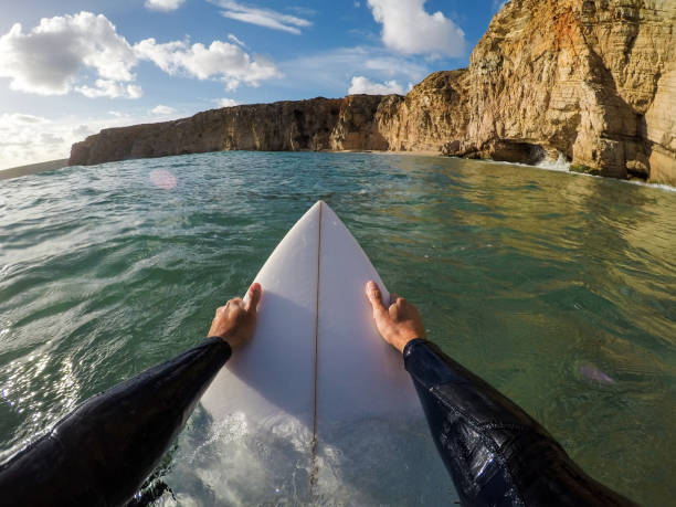 istock Surfer holding a surfboard in water 1077801268