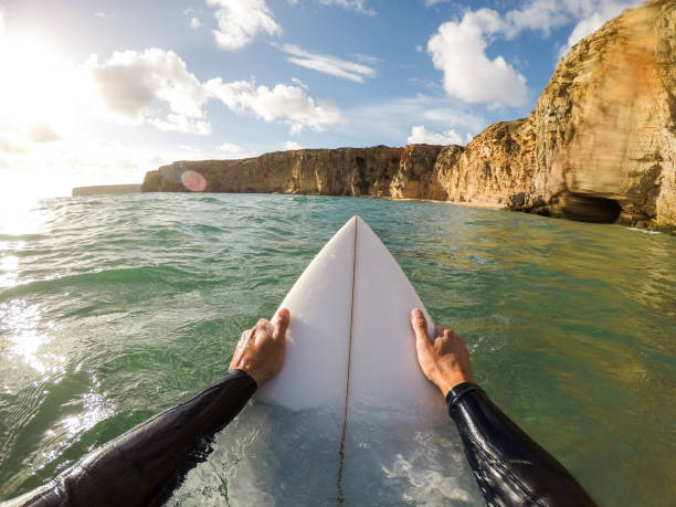 persona que practica surf con una tabla de surf en el agua - perspectiva personal fotografías e imágenes de stock