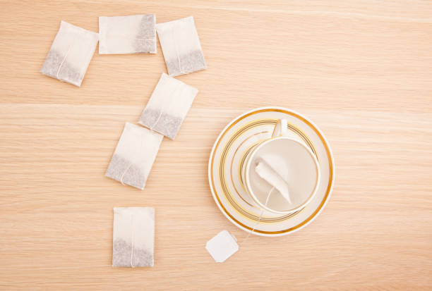 istock tea pockets question mark cup wooden table nobody 1077809192