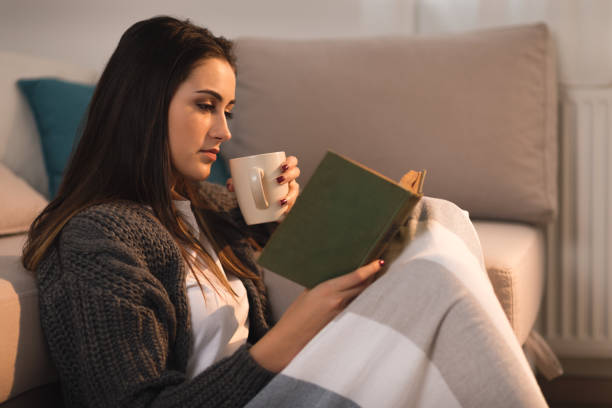 istock Relaxed young woman reading a book at home. 1077809328