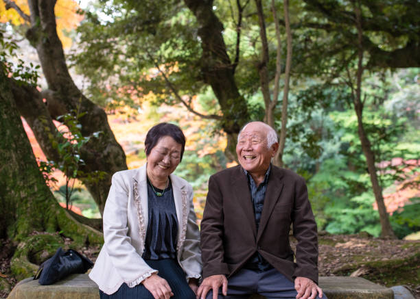 Happy senior couple taking a break in forest stock photo