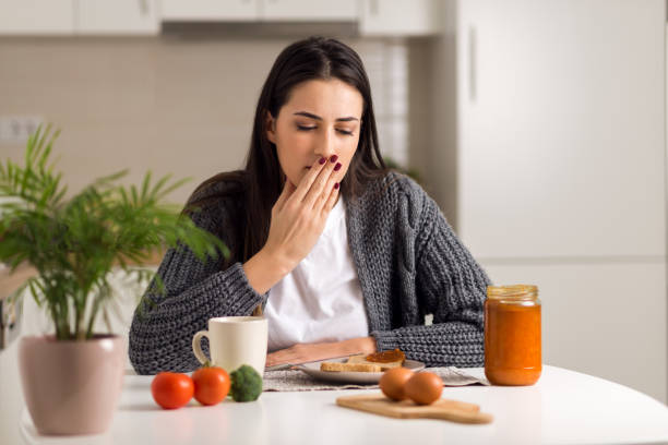 Young  woman feeling nausea during breakfast time Young woman feeling nausea during breakfast time at home nausea photos stock pictures, royalty-free photos & images