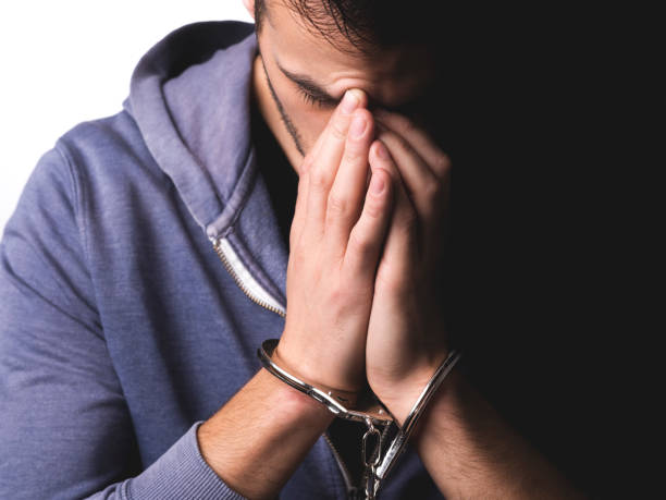 Young man arrested with handcuffs on his hands stock photo