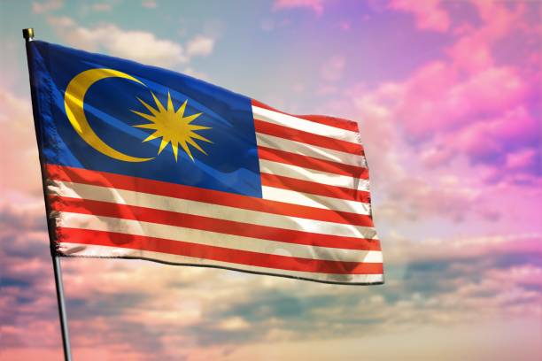 istock Fluttering Malaysia flag on colorful cloudy sky background. Prosperity concept. 1077819444