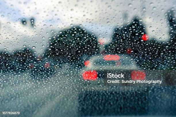 Raindrops On The Windshield On A Rainy Day Car Stopped At A Traffic Light In The Background Stock Photo - Download Image Now