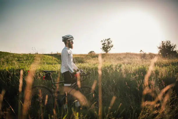 Cyclist taking rest by the country side road enjoying the environment