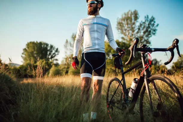 Cyclist taking rest by the country side road enjoying the environment