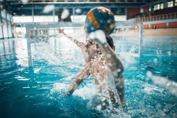 Waterpolo action Father and son having fun in the pool playing water polo water polo photos stock pictures, royalty-free photos & images