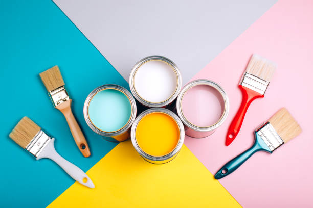 istock Four open cans of paint with brushes on bright background. 1077835446