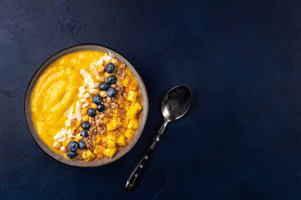istock Top view of mango smoothie bowl with fruits 1077842774