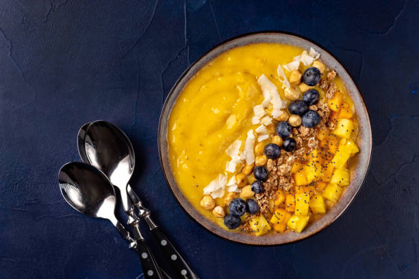 istock Top view of mango smoothie bowl with fruits 1077842834