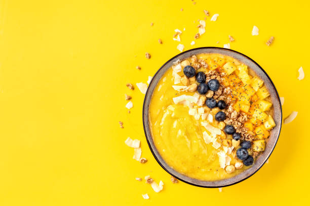 istock Top view of mango smoothie bowl with fruits 1077842852