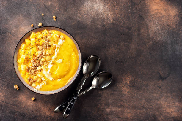 istock Top view of mango smoothie bowl with fruits 1077842874
