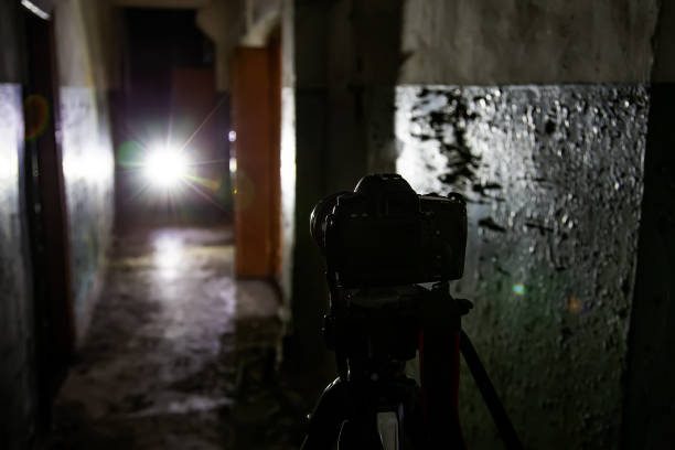 istock Camera on tripod in dark abandoned building. Urban exploration concept 1077845904