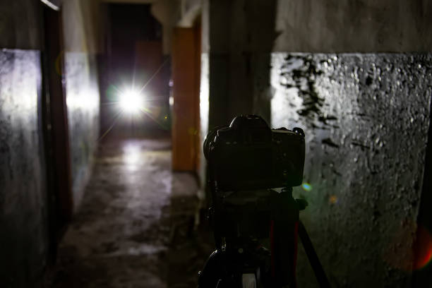 Camera on tripod in dark abandoned building. Urban exploration concept