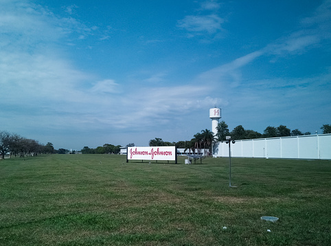 Johnson and Johnson. Pharmaceutical, cosmetic and medical device company located in Brazil. Detail of the green field where the factory is located and its sign with the traditional logo.