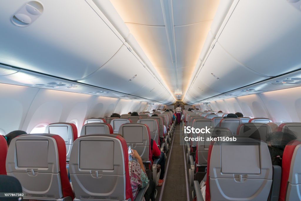 Innenraum des Flugzeugs mit Passagieren auf Sitze und Stewardess in Uniform zu Fuß den Gang. - Lizenzfrei Flugzeug Stock-Foto