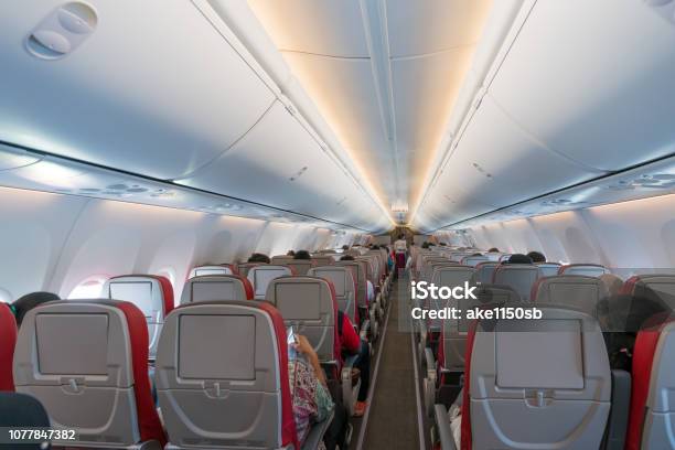 Innenraum Des Flugzeugs Mit Passagieren Auf Sitze Und Stewardess In Uniform Zu Fuß Den Gang Stockfoto und mehr Bilder von Flugzeug