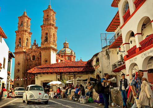Taxco, Mexico - November 19, 2016: Mini taxi (Volkswagen Beetle) against the Cathedral of Taxco, Mexico.