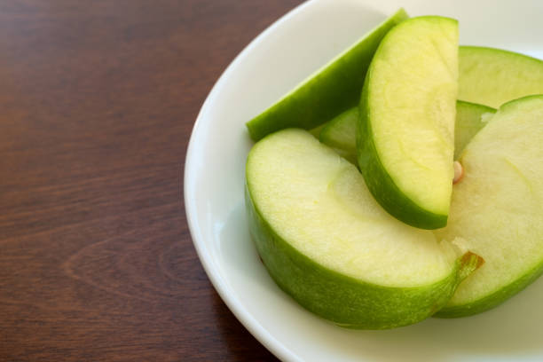 istock Sliced apples snack meal on a white plate 1077851954